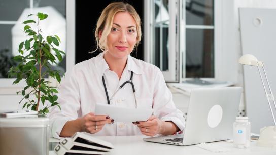 Plastic Surgeon sitting at desk