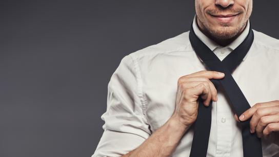 Man after chin augmentation tying tie