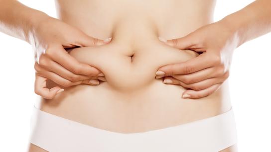 Woman squeezing excess tummy fat