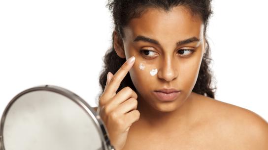 Woman applying eye cream to under-eye circles