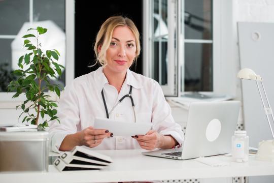 Plastic Surgeon sitting at desk