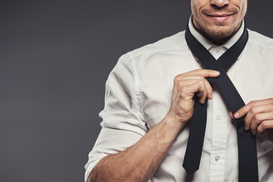 Man after chin augmentation tying tie