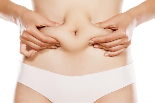 Woman squeezing excess tummy fat