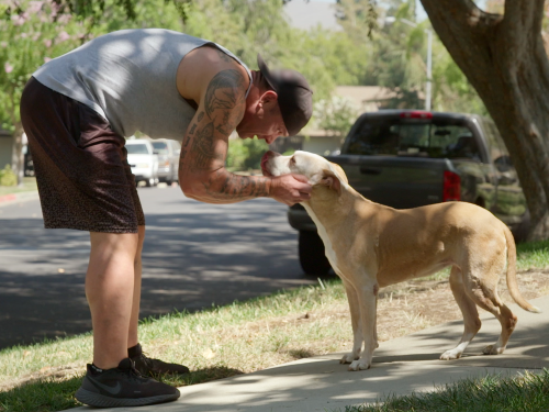 Colby enjoys a moment with his dog